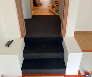 Découpe du tapis anthracite dans un angle de l'escalier